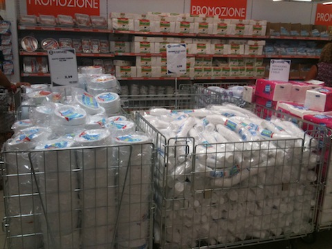 Supermarket shelves disposable plates, plastic cups and paper serviettes